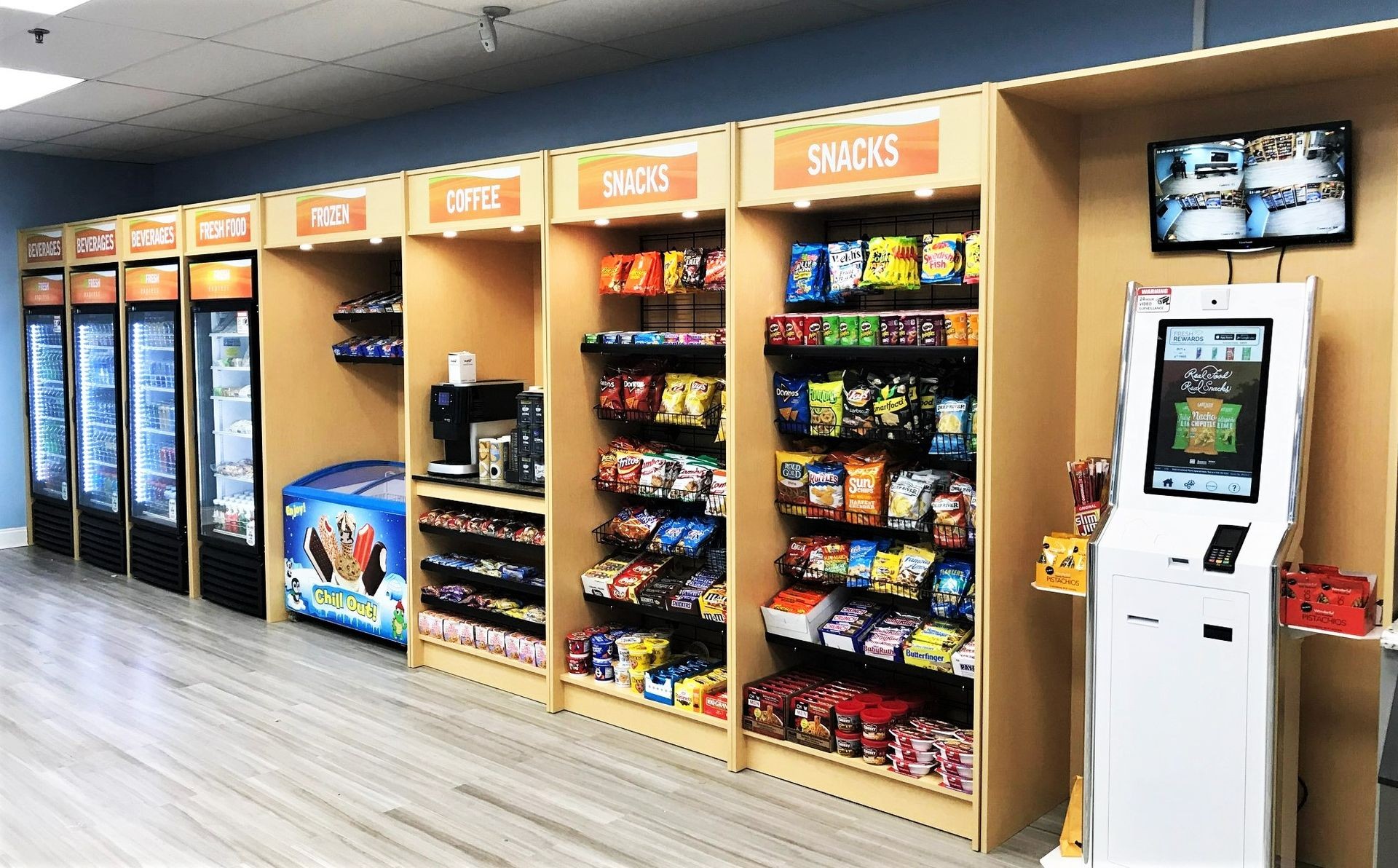 A modern micro market setup by eSafe Vending with a variety of snacks, beverages, and fresh food options displayed on shelves and in coolers.